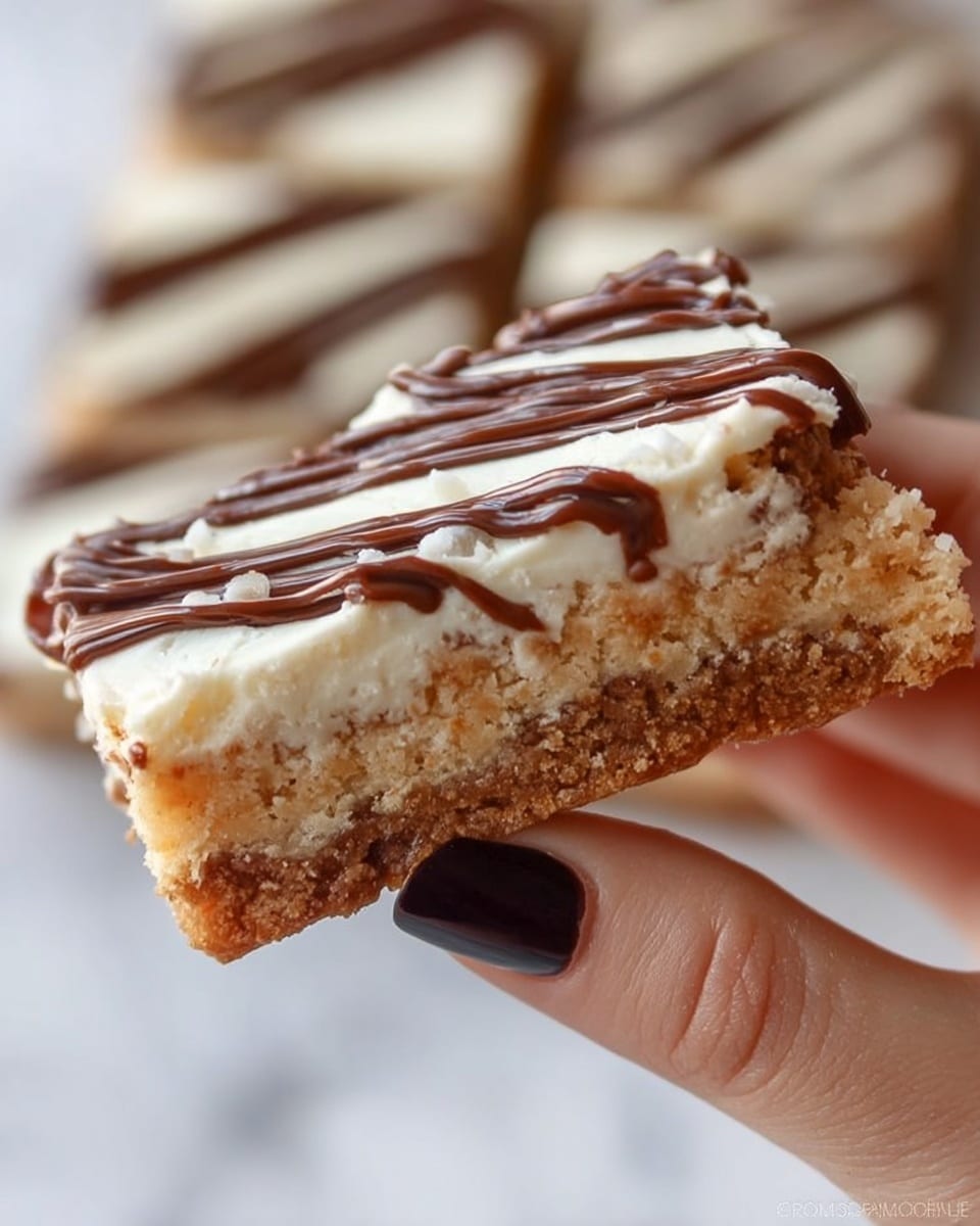 A large, light brown flat baked dessert, with a slightly rough texture and small risen parts, is being spread with a thick layer of smooth, white cream. A woman's hand holds a silver spatula that spreads the cream evenly on the top left part of the dessert. In the background, a shiny silver bowl filled with more white cream is slightly out of focus. The entire scene sits on a white marbled surface photo taken with an iphone --ar 4:5 --v 7