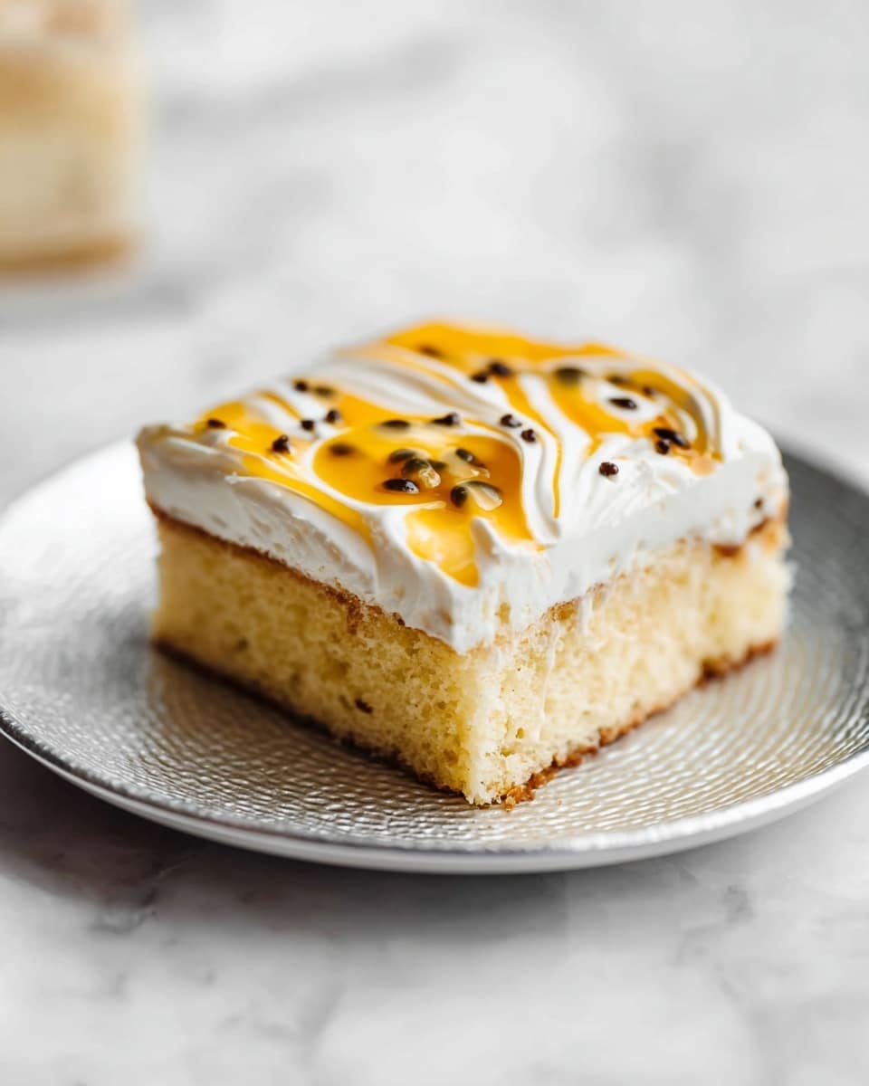 A single piece of light golden cake with a soft texture sitting on a white plate with a slightly hammered metal look, placed on a white marbled surface. The cake has two layers visible: a thick, moist yellowish base and a thin layer above it. On top is a generous layer of smooth white cream with swirls of bright orange sauce and small dark round seeds scattered on top. The background is softly blurred with a white marbled texture beneath. Photo taken with an iphone --ar 4:5 --v 7