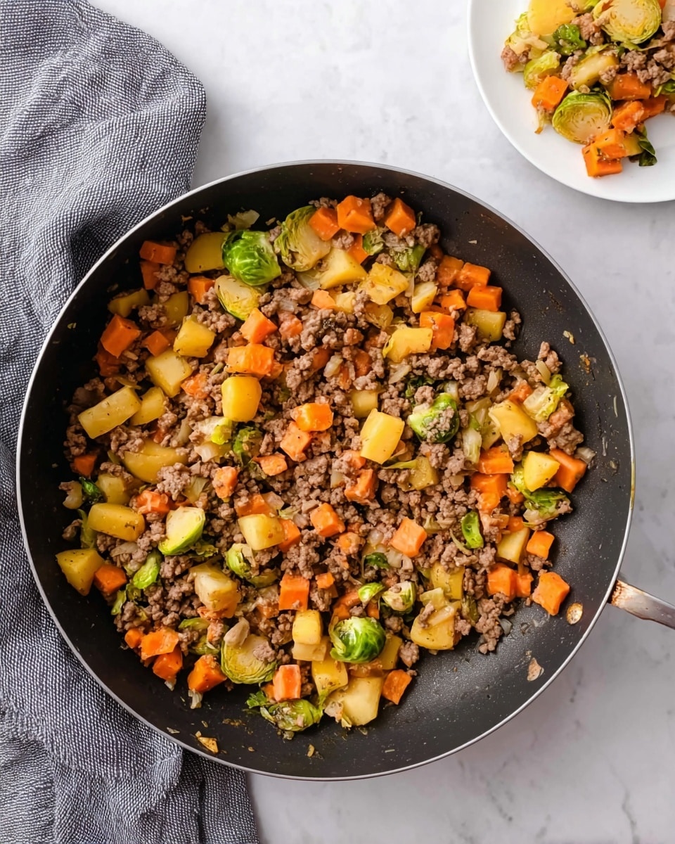 A black pan filled with a mix of three main layers: the bottom layer has small light brown cooked ground meat, the middle layer contains bright orange carrot pieces, and the top layer shows chunks of golden yellow potato and some green Brussels sprout leaves scattered throughout. The pan rests on a white marbled surface with a gray cloth to the left. In the top right corner, there is a white plate holding a small portion of the same dish. photo taken with an iphone --ar 4:5 --v 7